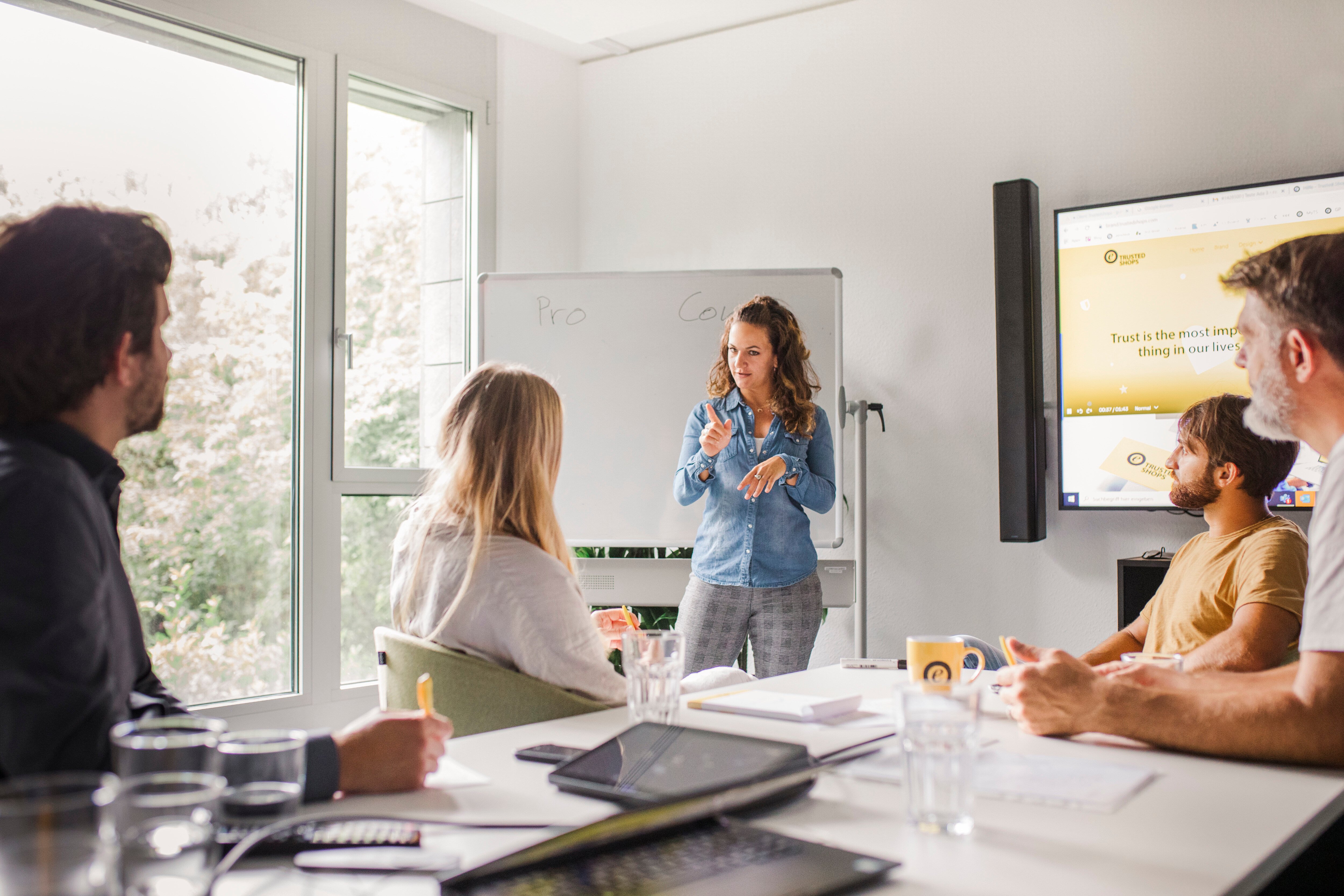 Five Trusted Shops employees are sitting in a meeting room brainstorming together. 