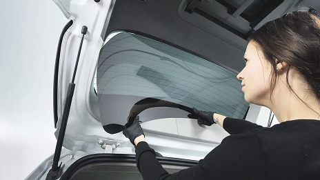 A woman changing the tinted windows of her car.