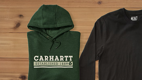 Photo of two sweaters. One is black with no text, the other is dark green with the text: Carhartt. Established 1889
